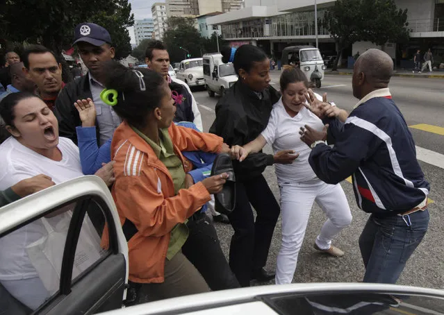 Cuban security personnel detain members of the Ladies in White group during a protest on International Human Rights Day, in Havana December 10, 2014. (Photo by Enrique de la Osa/Reuters)