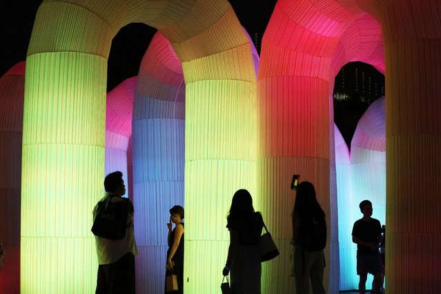 People visit Sky Castle by ENESS, an interactive sound and light installation, during the opening of the Singapore Night Festival (SNF) 2025 in Singapore, 22 August 2025. The 16th edition of SNF, themed Island Nights, opens on 22 August with over 80 immersive and innovative experiences. (Photo by How Hwee Young/EPA)
