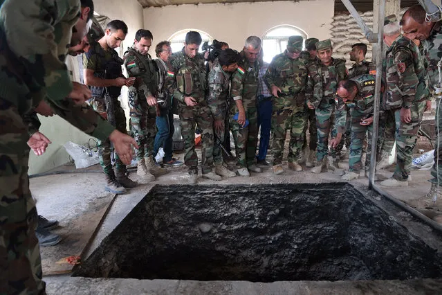 Kurdish Peshmerga soldiers stand around a tunnel dug by ISIS in a house recently recaptured by the Kurds during the battle to retake Mosul, on October 18, 2016 in Bartella, near Mosul in Iraq. Joint forces from countries including Britain, U.S.A and France have joined Iraq and Iraqi Kurdistan to launch what is believed to be the largest ground operation since the invasion of Iraq in 2003 to retake Iraq's second largest city from the Islamic State who have held it since 2014. (Photo by Carl Court/Getty Images)