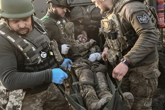 A wounded Ukrainian seviceman is being carried away from the front line near Bakhmut, on March 23, 2023, amid Russian invasion of Ukraine. (Photo by Aris Messinis/AFP Photo)