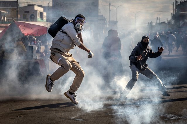 A protester jumps to avoid a teargas canister during clashes with Malagasy security forces at a demonstration calling for the resignation of President Andry Rajoelina, in Antananarivo, on October 6, 2025. Hundreds of people demonstrated in Madagascar's capital, Antananarivo, on Monday – the 12th day of a youth-led protest movement that has plunged the country into political crisis Near-daily protests that started on September 25 against persistent water and power cuts in the Indian Ocean island have grown into an anti-government movement calling for President Andry Rajoelina to resign. (Photo by Luis Tato/AFP Photo)