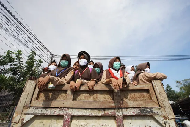 People wear masks to travel through the streets after an eruption of the Mount Merapi volcano in Java, Indonesia on May 11, 2018. (Photo by Cyrilus Yuniarto Purnomo/Sijori Images/Barcroft Images)