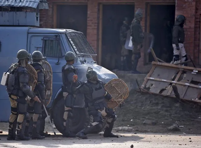 An Indian paramilitary soldier throws a stone towards protesters during a demonstration in Srinagar, November 27, 2015. Indian police used teargas and fired rubber bullets to disperse hundreds of people protesting after Friday prayers in the Kashmir Valley against the alleged arrest of stone-pelting youths by Indian police. (Photo by Danish Ismail/Reuters)