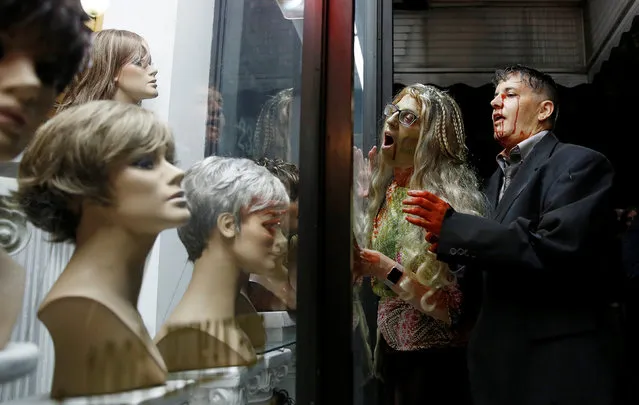 Zombies clamor for wig mannequins during the annual Silver Spring Zombie Walk before Halloween in Silver Spring, Maryland, U.S., October 29, 2016. (Photo by Gary Cameron/Reuters)