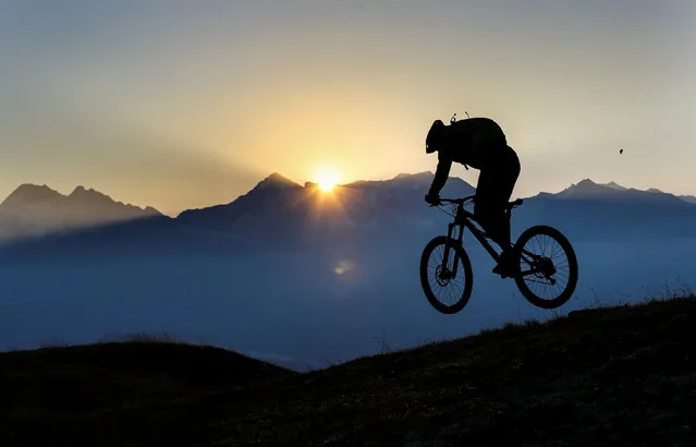 A man rides his mountain bike on a trail atop Eggerberg mountain as the sun rises, in the western Austrian village of Noesslach, Austria September 30, 2016. (Photo by Dominic Ebenbichler/Reuters)