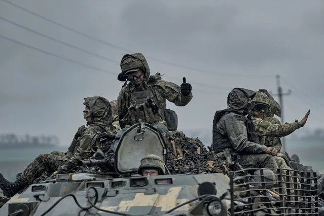 Ukrainian servicemen ride atop by an APC towards frontline positions near Vuhledar, Donetsk region, Ukraine, Monday, May 1, 2023. (Photo by Libkos/AP Photo)