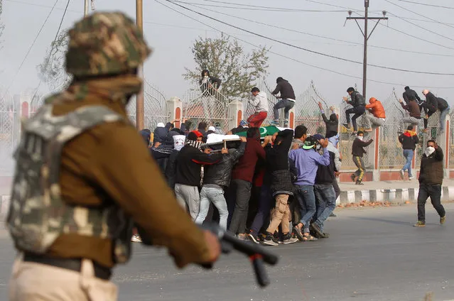 People carrying the body of Qaiser Sofi, a 16-year old Kashmir boy whose family said in local media reports was poisoned and tortured by police after he was went missing on October 27 and was found unconscious in a drain next day, run as they are chased by Indian police during his funeral after he died in a hospital on Friday night in Srinagar November 5, 2016. Police denied the charge and suspected the boy might have consumed poison on his own, media reports added. (Photo by Danish Ismail/Reuters)