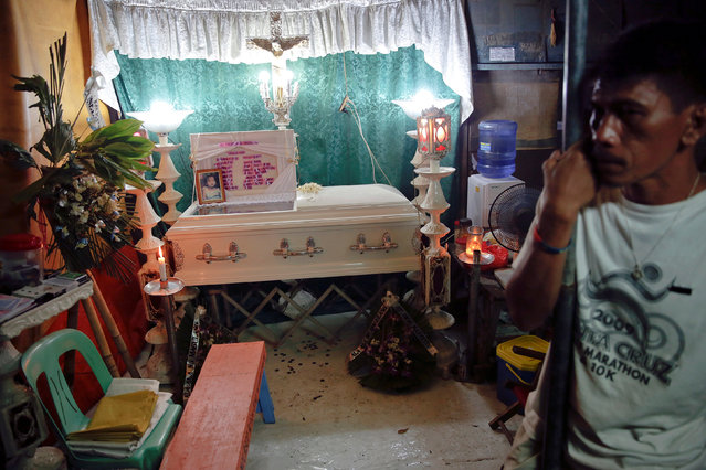 Father leans against a pole next to the coffin of his 7 year old daughter killed at Tugatog public cemetery, as friends and relatives gather for the wake in Manila, Philippines October 25, 2016. (Photo by Damir Sagolj/Reuters)