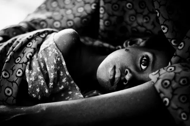 “Eyes”. At the hospital of Dadaab's Refugee Camp a weak little girl is hold by her mother. Location: Dadaab, Garissa District, North Eastern Province, Kenya. (Photo and caption by Lucas Mello/National Geographic Traveler Photo Contest)