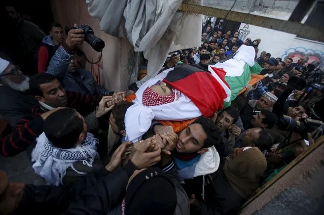 Mourners carry the body of Palestinian Sami Madi, whom medics said was killed by Israeli troops during clashes between Israeli troops and Palestinian protesters on Friday, during his funeral in Deir al-Balah in the central Gaza Strip December 12, 2015. (Photo by Suhaib Salem/Reuters)