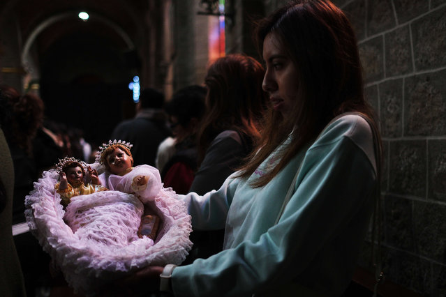 A woman holds images of the baby Jesus, in La Paz, Bolivia, 06 January 2025. Thousands of parishioners celebrated Three Kings' Day in Bolivia this 06 January with the religious custom of taking images of the Baby Jesus to Catholic churches to ask for 'peace and health' for the country this year. (Photo by Luis Gandarillas/EPA/EFE)