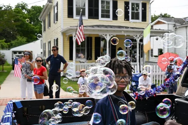 Javon Buckner, 12, is framed by bubbles while riding in a truck during the 4th of July Parade on Monday July 04, 2023 in Leesburg, VA. (Photo by Matt McClain/The Washington Post)