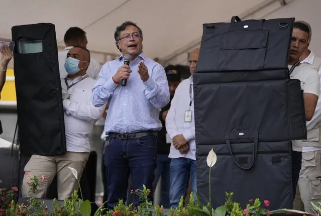Flanked by bulletproof shields, presidential candidate Gustavo Petro of the Historical Pact coalition speaks to his supporters during a campaign rally in Fusagasuga, Colombia, Wednesday, May 11, 2022. (Photo by Fernando Vergara/AP Photo)