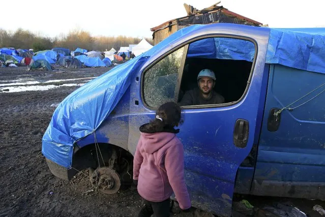 A 42-year-old man, who identified himself as Adam, a migrant from Kurdistan, sits in an abandoned van that he uses for  shelter in a muddy field called the Grande-Synthe jungle, a camp of tents and makeshift shelters where migrants and asylum seekers from Irak, Kurdistan and Syria gather in Grande-Synthe, France, December 29, 2015. (Photo by Pascal Rossignol/Reuters)