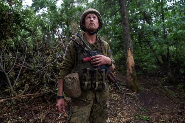 A Ukrainian serviceman of the 57th Kost Hordiienko Separate Motorised Infantry Brigade looks into the sky for enemy drones, amid Russia's attack on Ukraine, at a position near the town of Chasiv Yar, Donetsk region, Ukraine n June 25, 2023. (Photo by Oleksandr Ratushniak/Reuters)