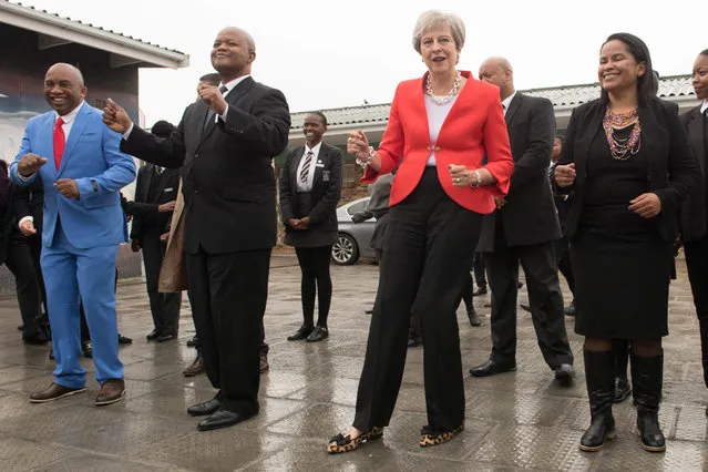 Prime Minister Theresa May dancing on August 28, 2018 with students and staff at I.D. Mkize Secondary School in Cape Town, which is twinned with Whitby High School in Yorkshire. The two schools are part of a British Council funded teacher exchange scheme called “Connected Classrooms”. The prime minister is on day one of her trip to South Africa, Nigeria and Kenya on a trade mission designed to bolster the UK's post-Brexit fortunes. (Photo by Stefan Rousseau/PA Images via Getty Images)