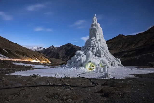 In this image released by World Press Photo, Thursday April 15, 2021, by Ciril Jazbec for National Geographic, titled One Way to Fight Climate Change: Make Your Own Glaciers, which won the second prize in the Environment Stories category, shows the youth group that built this ice stupa in the village of Gya installed a café in its base in India, March 19, 2019. They used the proceeds to take the village elders on a pilgrimage. (Photo by Ciril Jazbec for National Geographic, World Press Photo via AP Photo)