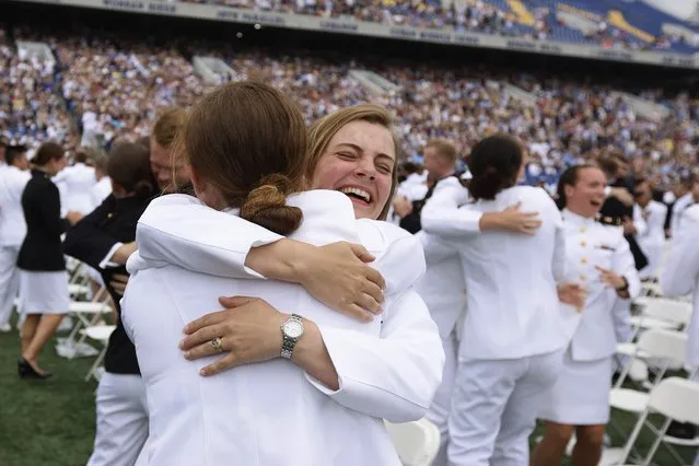 U.S. Naval Academy graduates embrace at the conclusion of their graduation and commissioning ceremony in the academy's Memorial Stadium on May 27, 2022 in Annapolis, Maryland. President Joe Biden delivered the commencement address to the a total of 1,100 sailors and Marines who graduated from the service academy. (Photo by Chip Somodevilla/Getty Images)