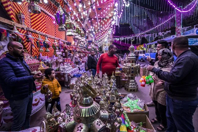 People shop from a stall selling Ramadan lanterns along a main street in the in the northern suburb of Shubra (home to a large Christian population) of Egypt's capital Cairo on April 12, 2021, at the start of the Muslim holy fasting month of Ramadan. (Photo by Khaled Desouki/AFP Photo)