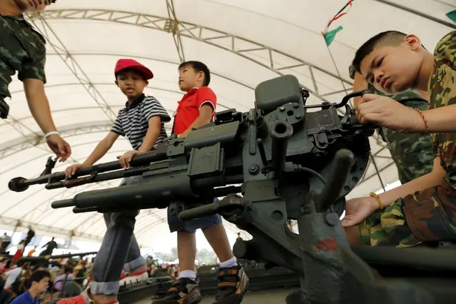 Children play with weapons on the top of a tank during the Children's Day celebration at a military facility in Bangkok, Thailand January 9, 2016. (Photo by Jorge Silva/Reuters)