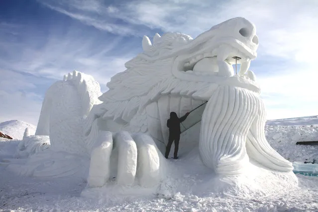 An artist makes a snow sculpture at Altay Ice and Snow World Park in Xinjiang Uygur, China on January 11, 2016. (Photo by Imaginechina/REX/Shutterstock)