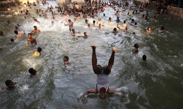 Faithful jump into the waters of the Fasilides Bath as part of a ceremony in which the waters are blessed by the priest of the Ethiopian Orthodox Tewahedo Church during the second day of Timket in Gondar, Ethiopia, January 20, 2016. (Photo by Tiksa Negeri/Reuters)
