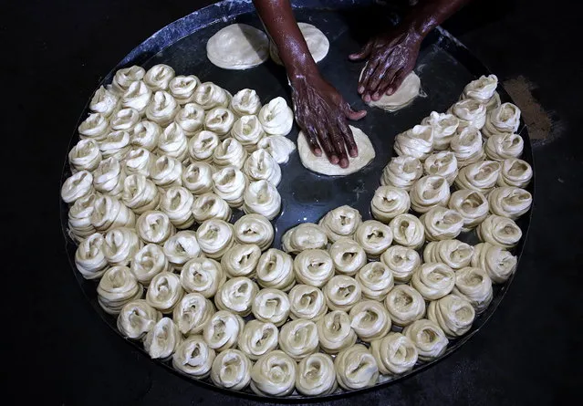 An Indian worker prepares material used for the making of vermicelli for the upcoming Hindu festival Karva Chauth in Tarore village, about 30km from Jammu, the winter capital of Kashmir, India, 24 October 2018. Karva Chauth is observed by married Hindu women who eat the traditionally prepared food vermicelli in the wee hours of the morning and fast until dusk praying for wedded bliss and a long life for their husbands. (Photo by Jaipal Singh/EPA/EFE)