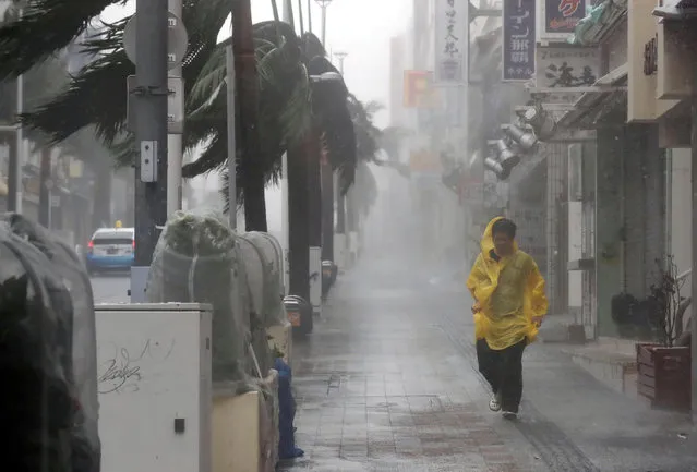 A passer-by walks in heavy rain and wind caused by Typhoon Trami in the prefectural capital Naha, on the southern island of Okinawa, in this photo taken by Kyodo on September 29, 2018. (Photo by Kyodo News via Reuters)