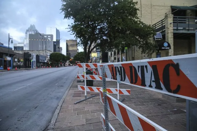 Road block barriers sit on the sidewalk on 6th Street after an early morning shooting on Saturday, June 12, 2021 in downtown Austin, Texas. Authorities say someone opened fire on the busy entertainment district wounding several people before getting away. (Photo by Aaron Martinez/Austin American-Statesman via AP Photo)