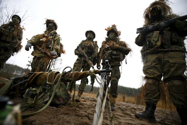 Participiants gather and listen to instructions during a territorial defence training organised by paramilitary group SJS Strzelec (Shooters Association) in the forest near Minsk Mazowiecki, eastern Poland March 14, 2014. (Photo by Kacper Pempel/Reuters)