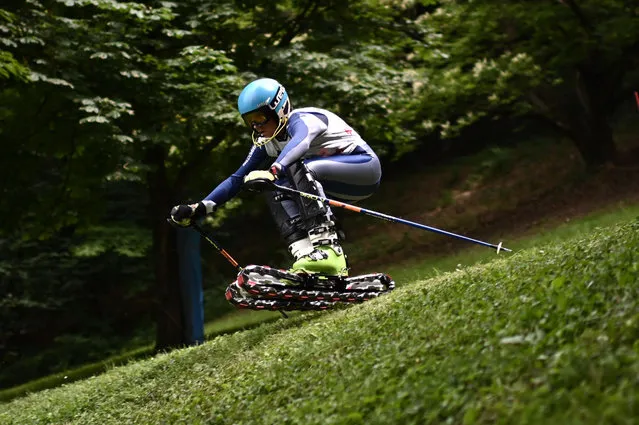 A skier competes in the trophy Talento Verde (Green talent), a slalom sprint challenge on the grass ski slope in Strada del Nobile in Turin, Northwestern Italy, on June 19, 2021. The ski slope is the first in a city in Italy with ski lift and it's totally devoted to this discipline. (Photo by Marco Bertorello/AFP Photo)