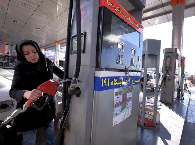 An Iranian woman puts a nozzle back after refuelling her car at a petrol station in Tehran, Iran, January 25, 2016. (Photo by Raheb Homavandi/Reuters/TIMA)