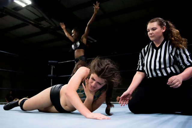 Professional wrestler Gia Scott (L) celebrates after choking Professional wrestler Aria Palmer (C) into submission and winning the match during Autumn Armageddon 2018 in Galena, Maryland on October 6, 2018. (Photo by Jim Watson/AFP Photo)