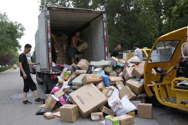 Workers sort out parcels for delivery in Beijing Wednesday, July 14, 2021. China's economic growth slowed to a still-strong 7.9% over a year ago in the three months ending in June as a rebound from the coronavirus leveled off. (Photo by Ng Han Guan/AP Photo)