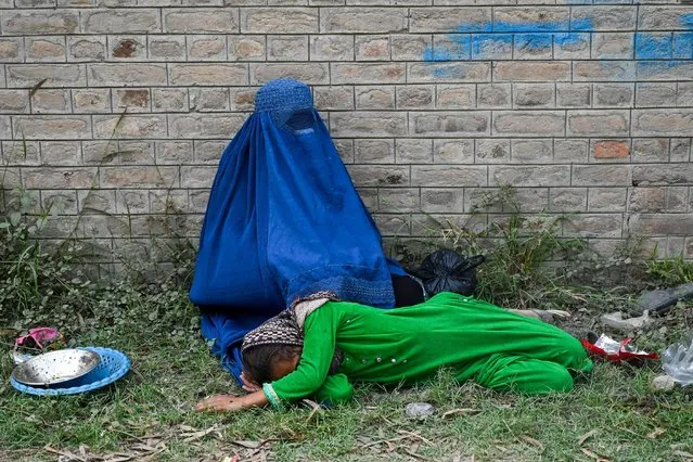 Afghan refugee women wait near the United Nations High Commissioner for Refugees (UNHCR) Azakhel Voluntary Repatriation Centre in Nowshera on October 30, 2023. Islamabad has issued an order to 1.7 million Afghans it says are living in the country illegally to leave by November 1, or be deported. (Photo by Abdul Majeed/AFP Photo)