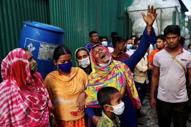 Unidentified relatives of the victims mourn at the site after a fire broke out at a factory named Hashem Foods Ltd. in Rupganj of Narayanganj district, on the outskirts of Dhaka, Bangladesh, July 9, 2021. (Photo by Mohammad Ponir Hossain/Reuters)
