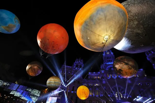 Balloons depicting planets fly over the crowds during the Twelfth Night procession in Madrid, Spain, 05 January 2017. The arrival of the “Reyes Magos” (Three Wise Men) marks the end of the Christmas season and celebrates Epiphany, which in Spain is the day when children and adults traditionally receive their Christmas presents. (Photo by Juanjo Martin/EPA)