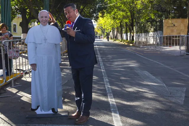 A TV journalist reports next to a life-size cutout of Pope Francis outside the Catholic Nunciature before the pontiff arrives in Mexico City, Friday, February 12, 2016. Pope Francis is arriving in Mexico on Friday for a week-long visit. (Photo by Christian Palma/AP Photo)