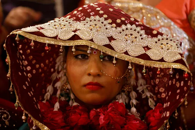 A bride in a wedding dress waits for her wedding to start during a mass marriage ceremony, organized by the Pakistan Hindu Council in Karachi, Pakistan, January 6, 2019. (Photo by Akhtar Soomro/Reuters)