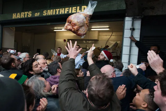 Members of Harts the Butchers sell off surplus meats during the annual Christmas Eve meat auction at Smithfield Meat Market in London, England, on December 24, 2013. (Photo by Peter Kollanyi/i-Images/ZUMA Press)