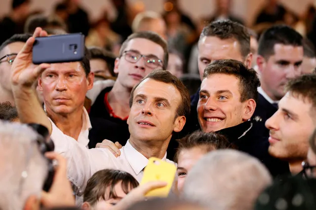 French President Emmanuel Macron takes a selfie as he attends a meeting with youths as part of the “Great National Debate” in Etang-sur-Arroux, France, February 7, 2019. (Photo by Emmanuel Foudrot/Reuters/Pool)