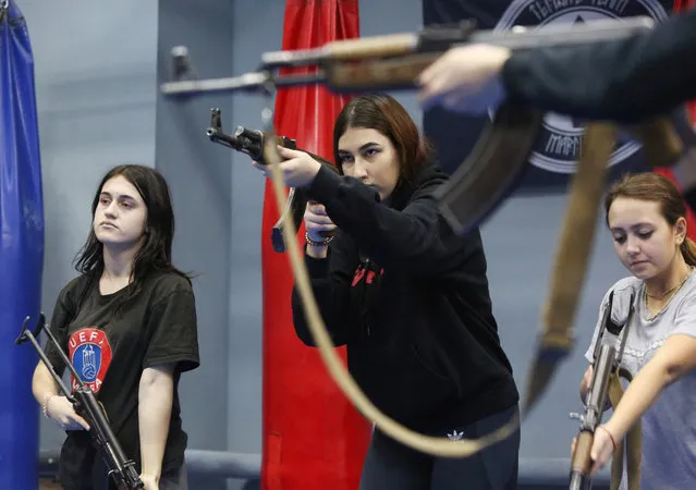 Ukrainian women and girls take part in a two-hour session to learn gun handling basics and hand-to-hand combat at a shopping mall in the Ukrainian city of Mariupol on January 26, 2019. Training in handling firearms is part of the self-defense courses for women that were established last year due to war that goes on in Ukraine's separatist east. Courses that are called “White Angels” and are totally free were organized by police officers and former soldiers who fought against Russia-backed rebels in about 20 kilometres (12 miles) from Mariupol. (Photo by Aleksey Filippov/AFP Photo)