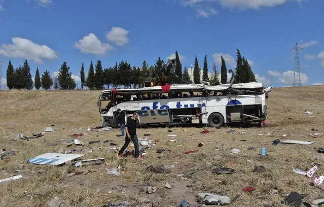 Officials investigate at the site of a bus crash, in Balikesir, western Turkey, Sunday, August 8, 2021. A passenger bus has veered and tumbled off a highway in western Turkey, killing 14 people. The governor’s office of Balikesir province said said the bus overturned at 04:40 local time (0140 GMT) on Sunday. (Photo by IHA via AP Photo)