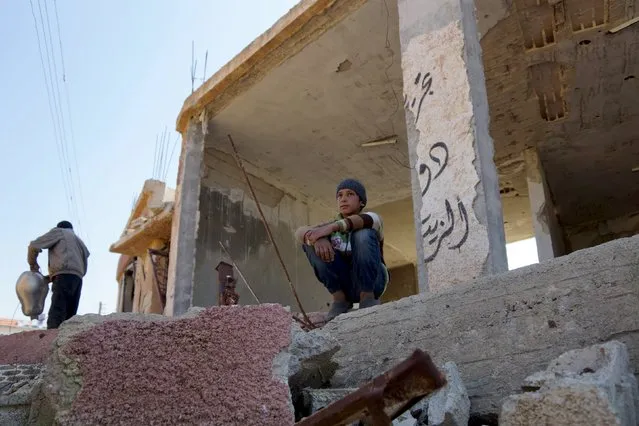 A boy sits at a damaged property in the rebel held al-Ghariyah al-Gharbiyah town, in Deraa province, Syria February 28, 2016. Picture taken February 28, 2016. (Photo by Alaa Al-Faqir/Reuters)