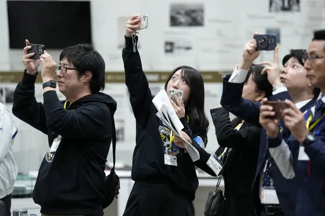 Staff of Japan Aerospace Exploration Agency (JAXA) watch a live streaming of the pinpoint moon landing operation  by the Smart Lander for Investigating Moon (SLIM) spacecraft observe a live streaming at JAXA's Sagamihara Campus Saturday, January 20, 2024, in Sagamihara near Tokyo. Japan's space agency said early Saturday that its spacecraft is on the moon, but is still “checking its status”. More details will be given at a news conference, officials said. (Photo by Eugene Hoshiko/AP Photo)