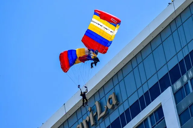 Sri Lankan paratroopers entangle during the Independence Day parade rehearsal in Colombo on January 30, 2024, troopers got injured after crashing onto a rooftop of a hotel overlooking the Galle Face sea-front promenade. (Photo by Ishara S. Kodikara/AFP Photo)