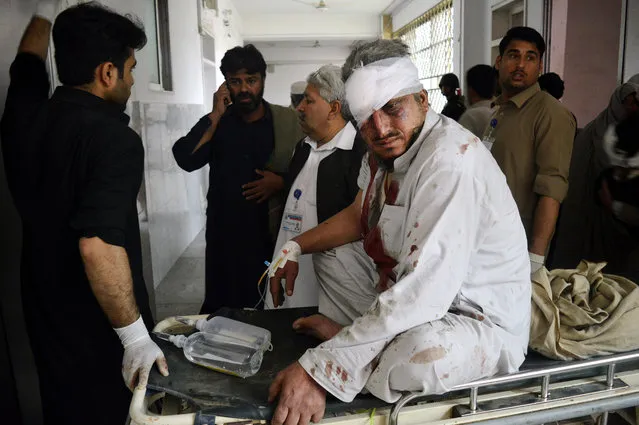 A Pakistani man who is injured in a bomb blast arrives at a local hospital in Peshawar, Pakistan, Wednesday, March 16, 2016. A bomb ripped through a bus carrying Pakistani government employees in the northwestern city of Peshawar on Wednesday, killing a number of people, police said. (Photo by Mohammad Sajjad/AP Photo)