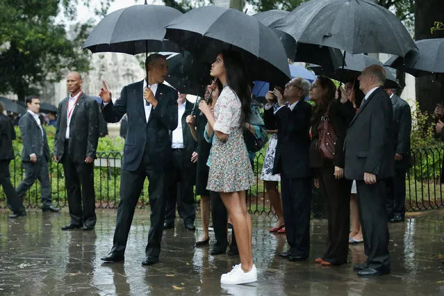 Taking shelter from the pouring rain under umbrellas, U.S. President Barack Obama, his daughter Malia, 17, and members of the first family take a walking tour of in the plaza of the 18th century Catedral de San Cristobal de la Habana in the historic Old Havana neighborhood March 20, 2016 in Havana, Cuba. Obama is the first sitting president to visit Cuba in nearly 90 years. (Photo by Chip Somodevilla/Getty Images)