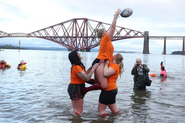 Revellers play with a ball, as they participate in a New Year's Day swim, locally often referred to as a “loony dook”, at South Queensferry, Scotland, Britain on January 1, 2023. (Photo by Russell Cheyne/Reuters)
