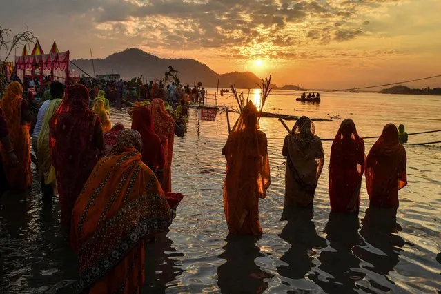 Hindu devotees offer prayers during “Chhat Puja” festival on the banks of the Brahmaputra River in Guwahati on November 10, 2021. (Photo by Biju Boro/AFP Photo)